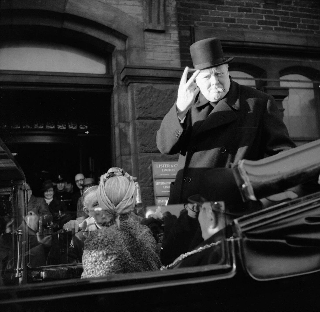 winston_churchill_cigar_in_mouth_gives_his_famous_v_for_victory_sign_during_a_visit_to_bradford_4_december_1942-_h25966