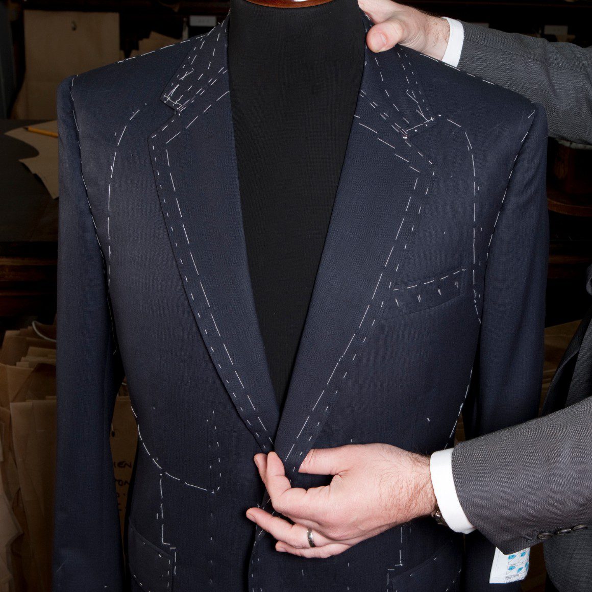 Tailor measuring for a bespoke suit